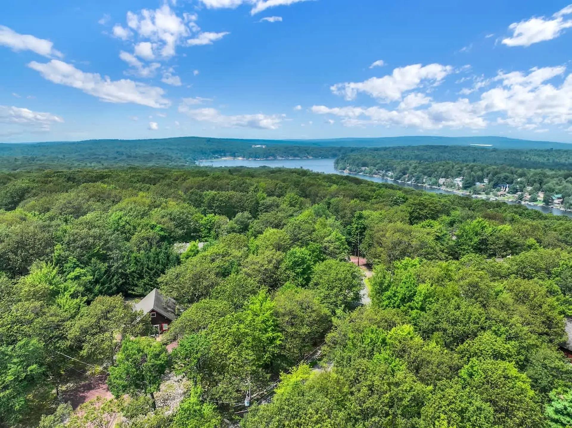 Panoramic aerial view of lush forest and lake landscape from a Poconos property